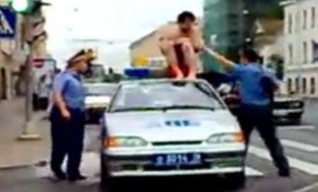 Un bărbat gol se urcă pe o maşină de poliţie în plin trafic (VIDEO)