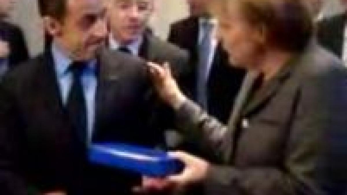 merkel il ironizeaza pe sarkozy si ii ofera cadou un stilou video