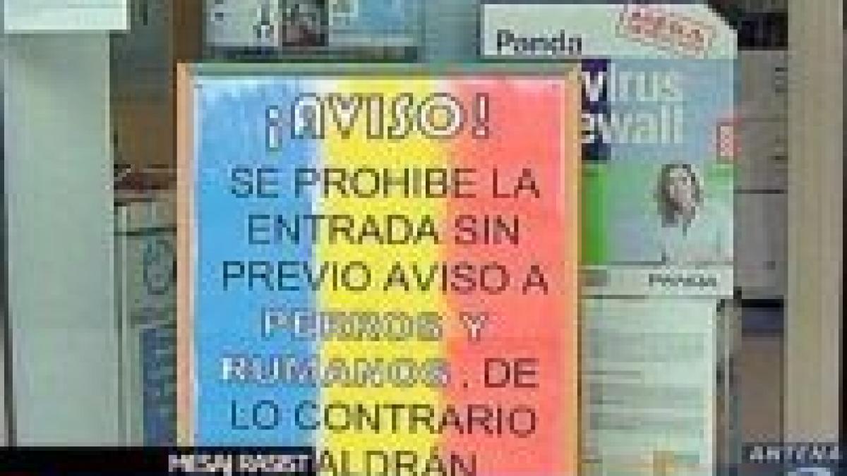 un afis interzice intrarea cainilor si romanilor intr un magazin din spania