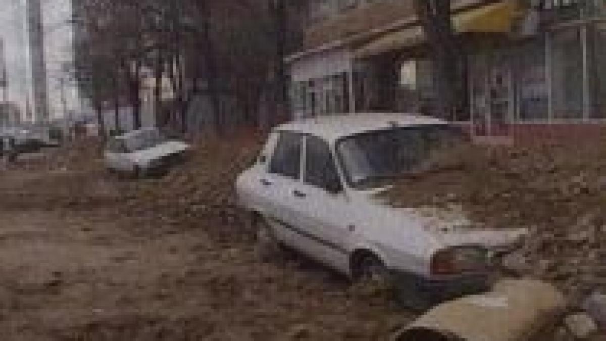 doua masini acoperite de pamant dupa ce muncitorii de la un santier au sapat in apropierea lor