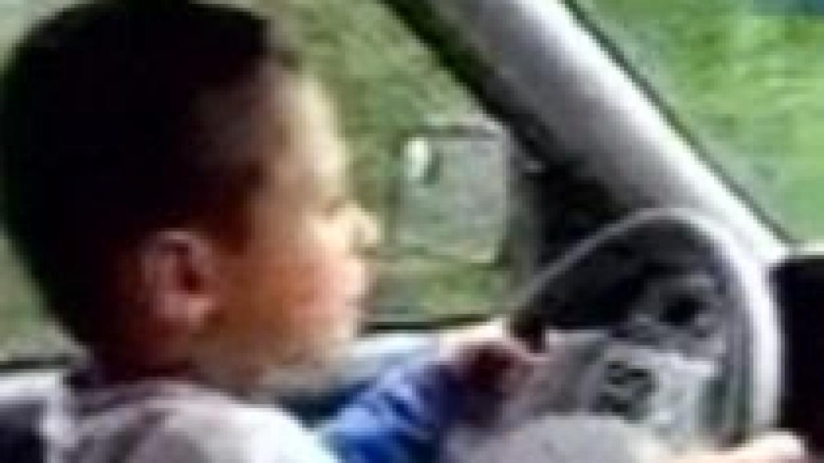 copil de sapte ani incurajat de tatal sau sa conduca o masina de teren video