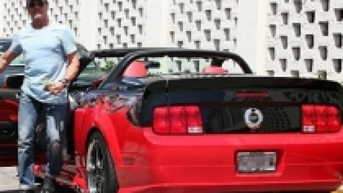 actorul sylvester stallone fotografiat cu doi copii pe locul din fata al masinii