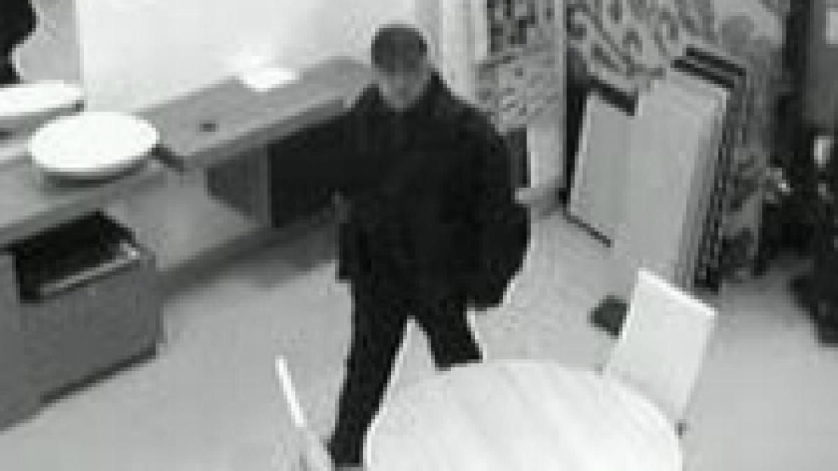 barbat filmat in timp ce fura un telefon dintr un birou foto