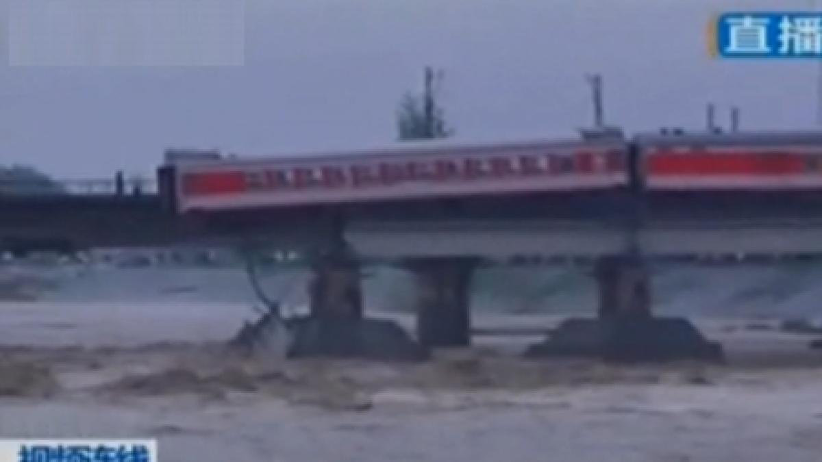 China: Sute de oameni la un pas de moarte, după ce un tren a rămas suspendat pe un pod rupt de ape (VIDEO)