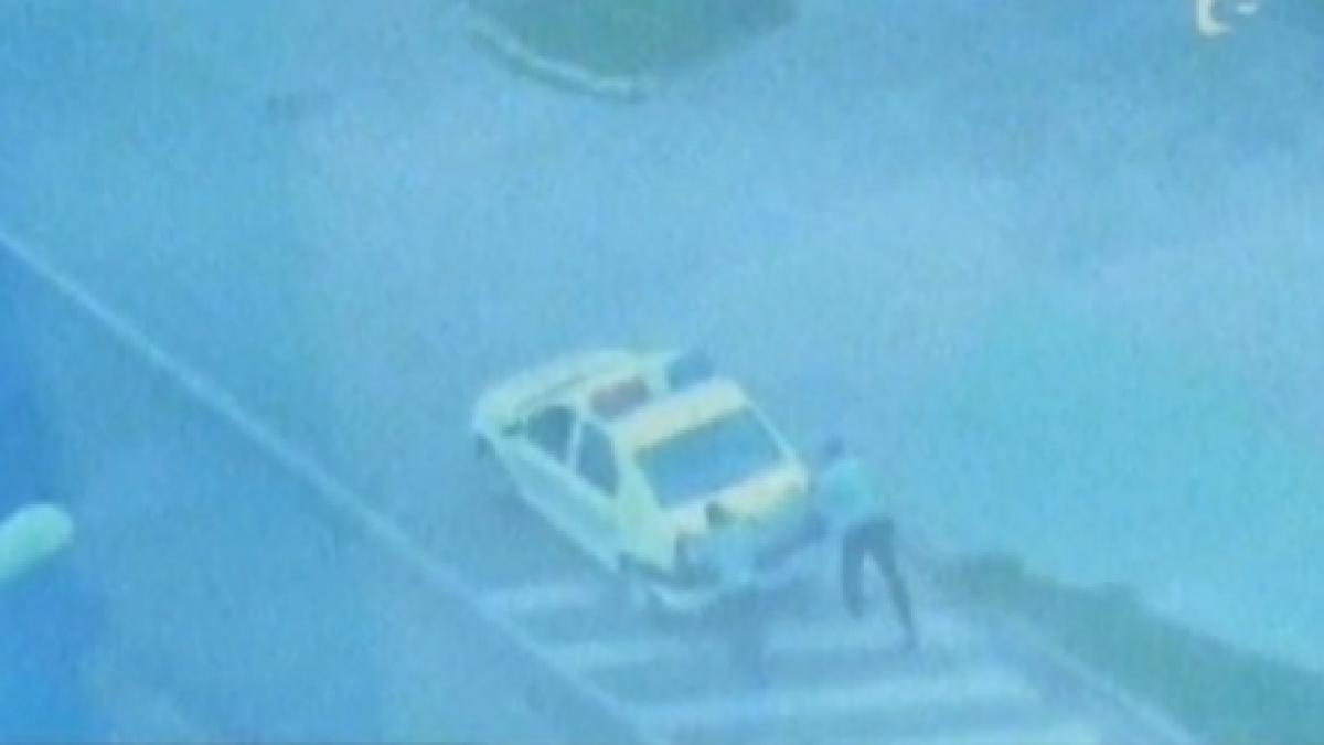 un echipaj de politie isi impinge masina dupa ce ramas fara benzina