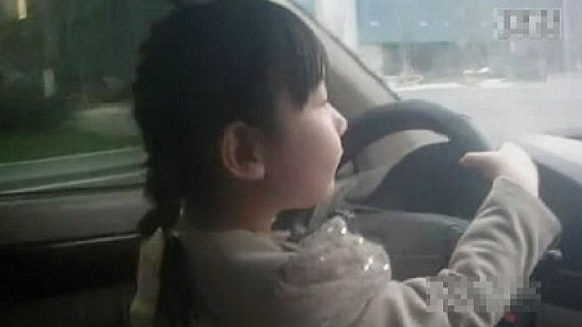 socant o fetita de 4 ani conduce masina pe o sosea aglomerata este filmata de mama ei