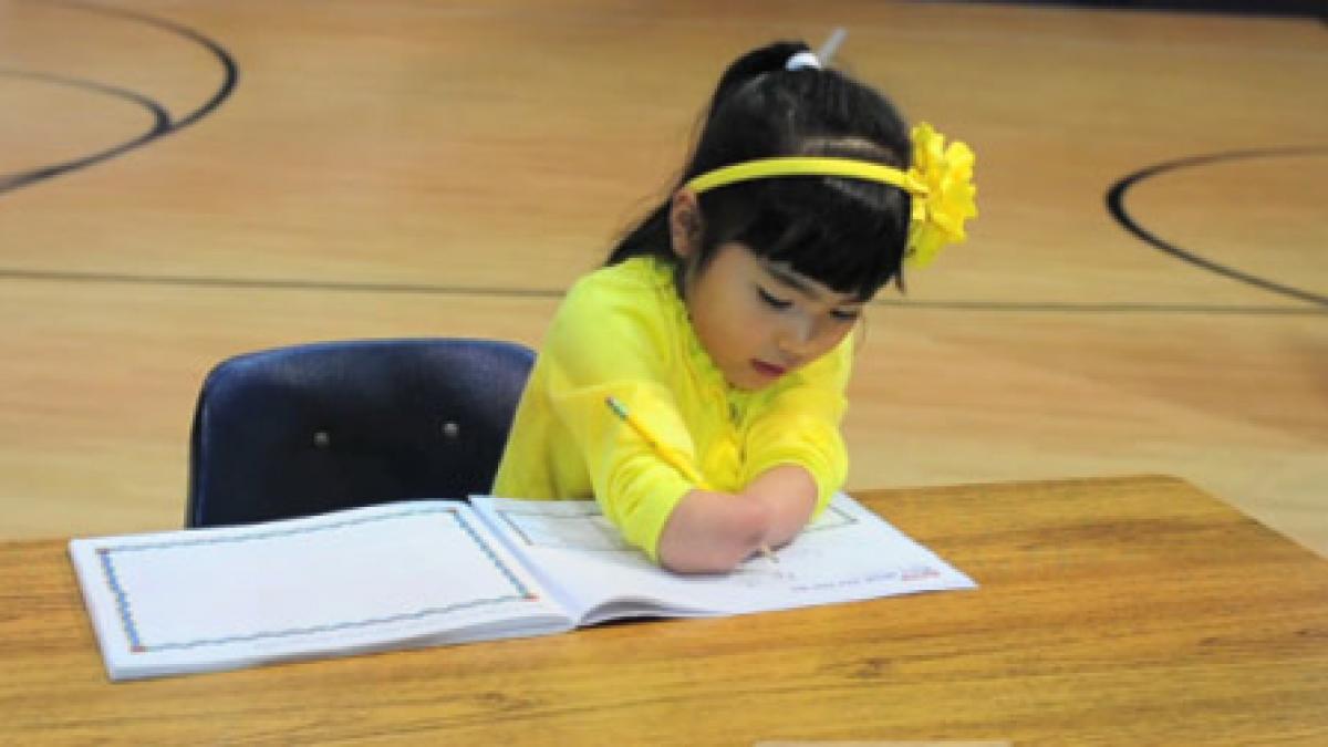 o fetita nascuta fara maini a castigat un concurs de caligrafie