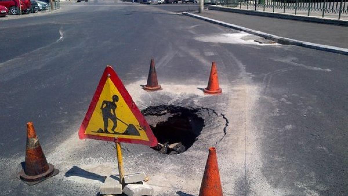 groapa de jumatate de metru langa guvern pe o strada asfaltata recent