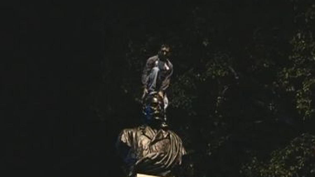 Protest inedit în Capitală. Vezi spectacolul dat de un bucureştean pe statuia liberalului Gheorghe Duca