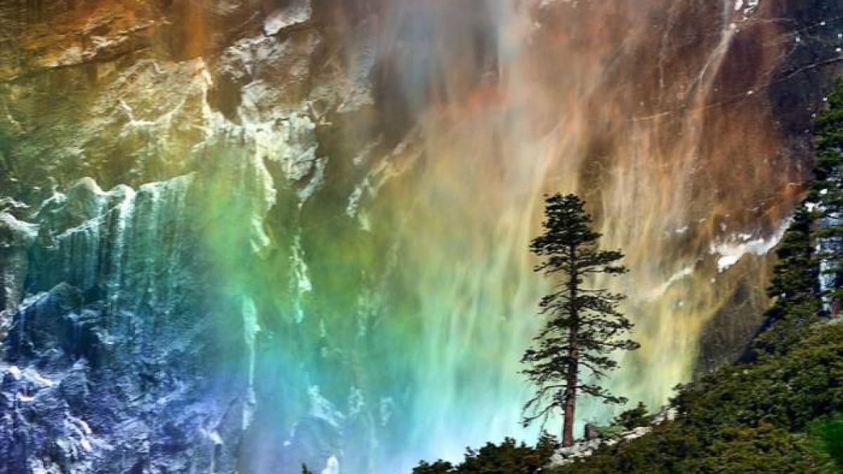 fotografia zilei un curcubeu superb se vede in jurul unei cascade