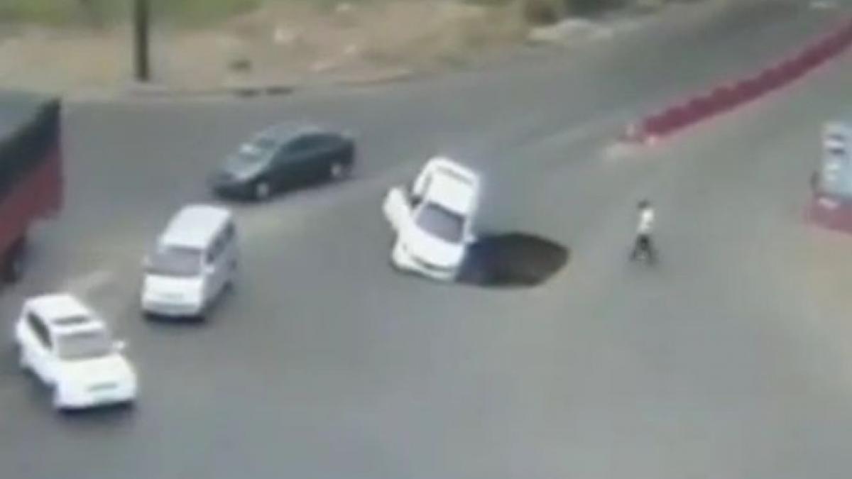 o groapa uriasa aparuta in mijlocul unei sosele din china a inghitit o masina vezi cum s a salvat