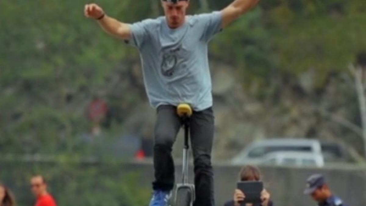 un roman merge cu un monociclu pe marginea barajului vidraru