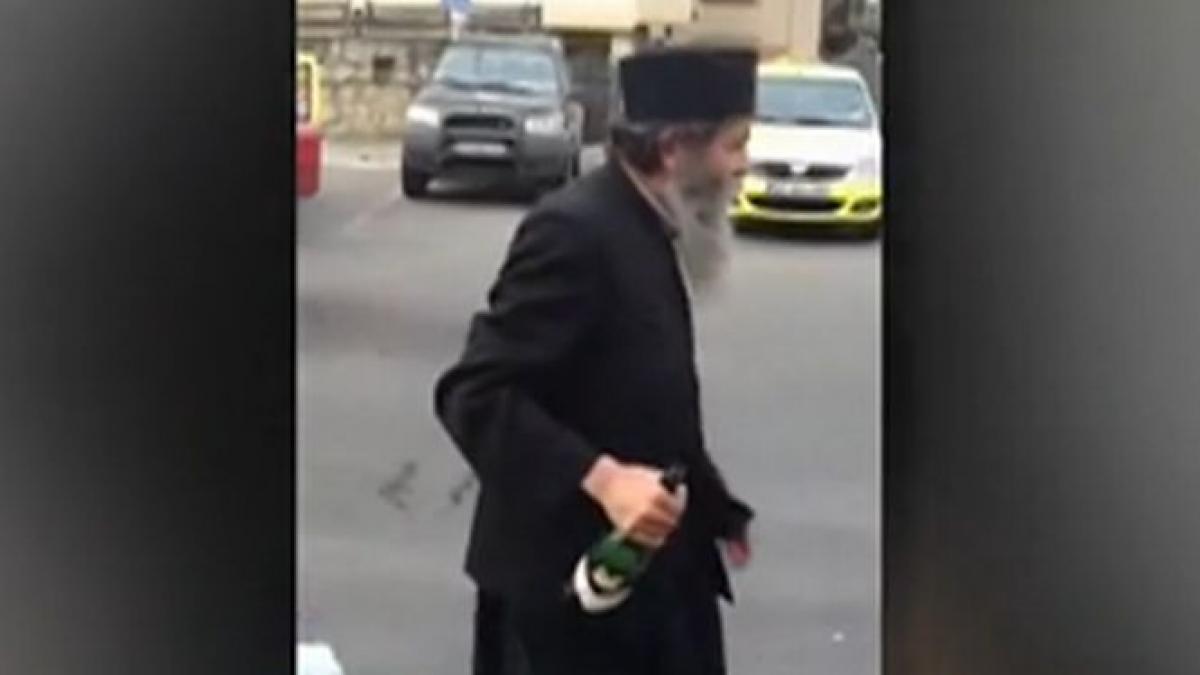 un calugar beat filmat in timp ce arunca vin dupa taximetristi