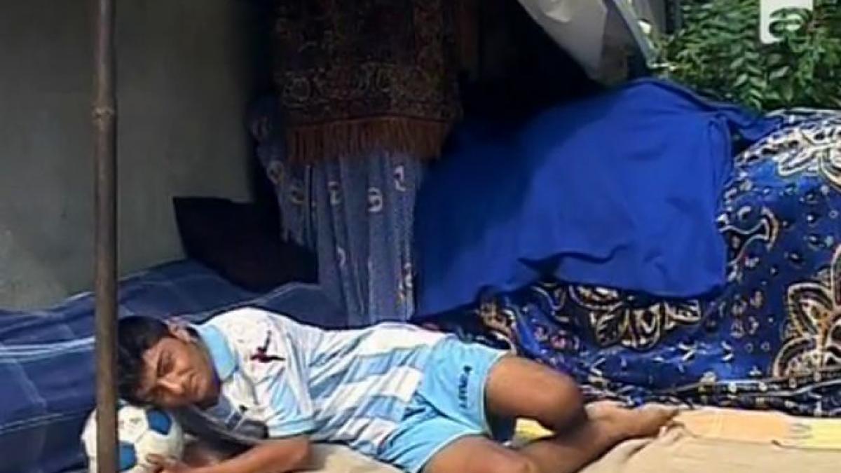 doarme sub cerul liber iar mingea de fotbal ii tine loc de perna