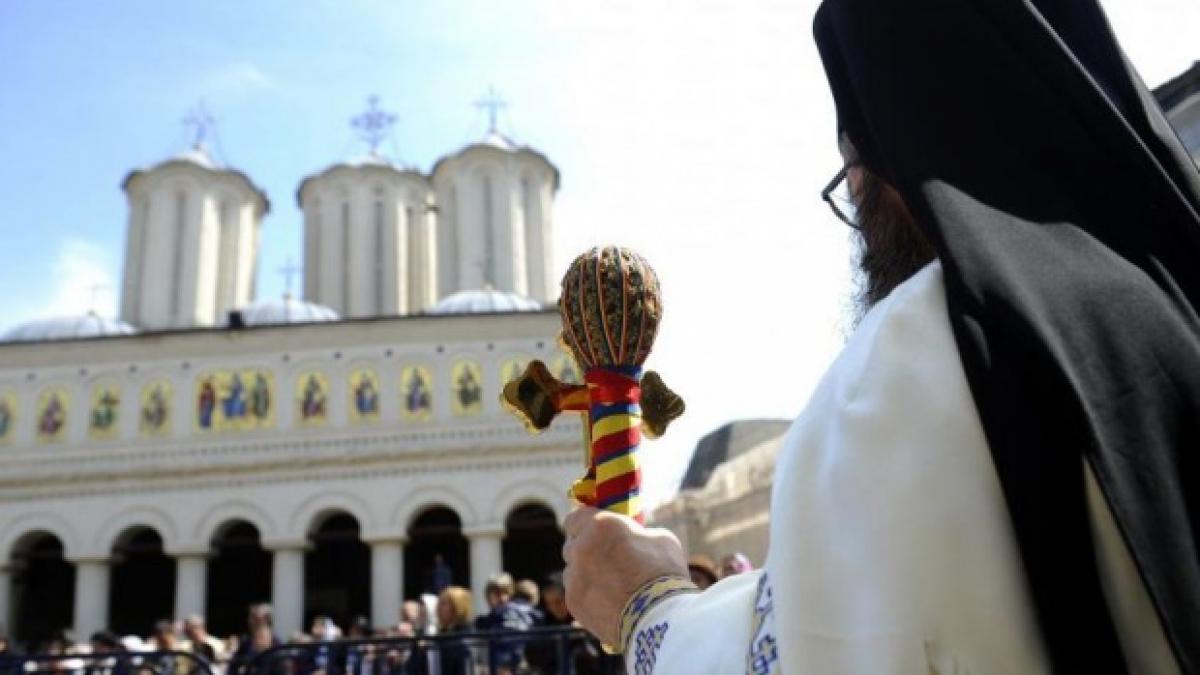 preotul care vorbeste la mobil in timpul slujbei