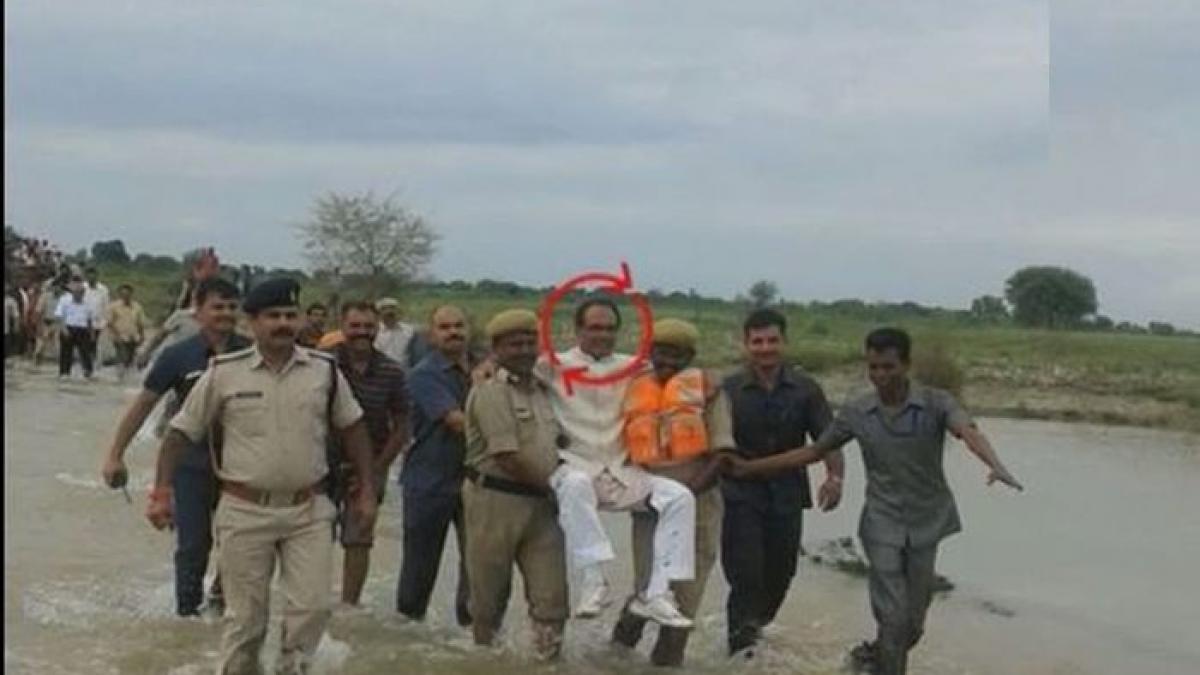 politician purtat pe brate ca sa nu si ude pantofii intr o zona distrusa de inundatii in india