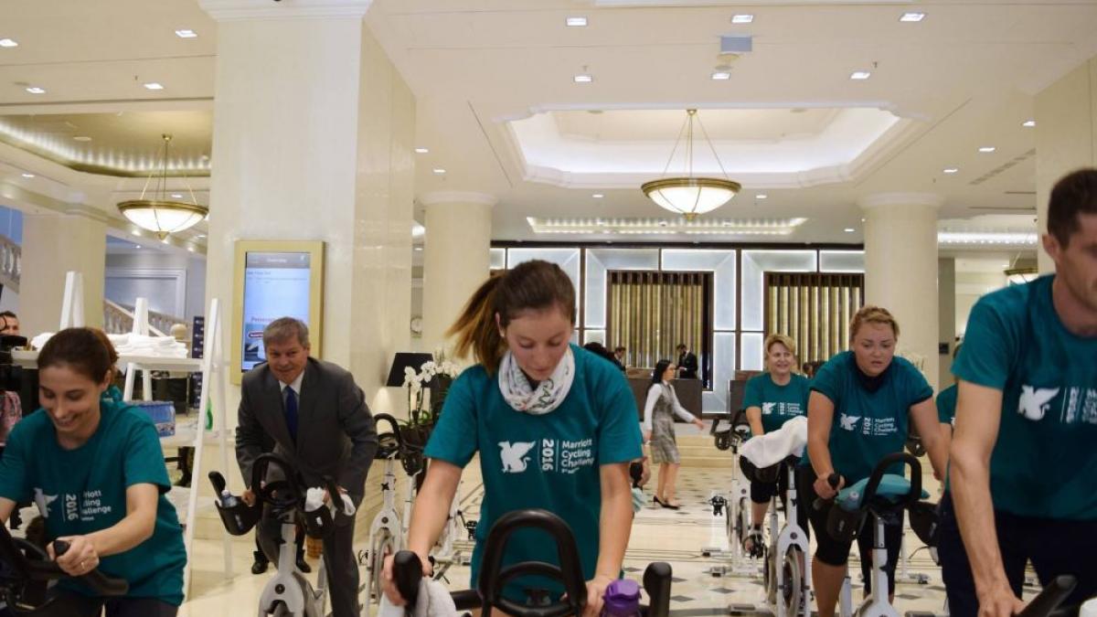 Dacian Cioloș, în costum, pe bicicletă. Premierul a pedalat într-un hotel din București