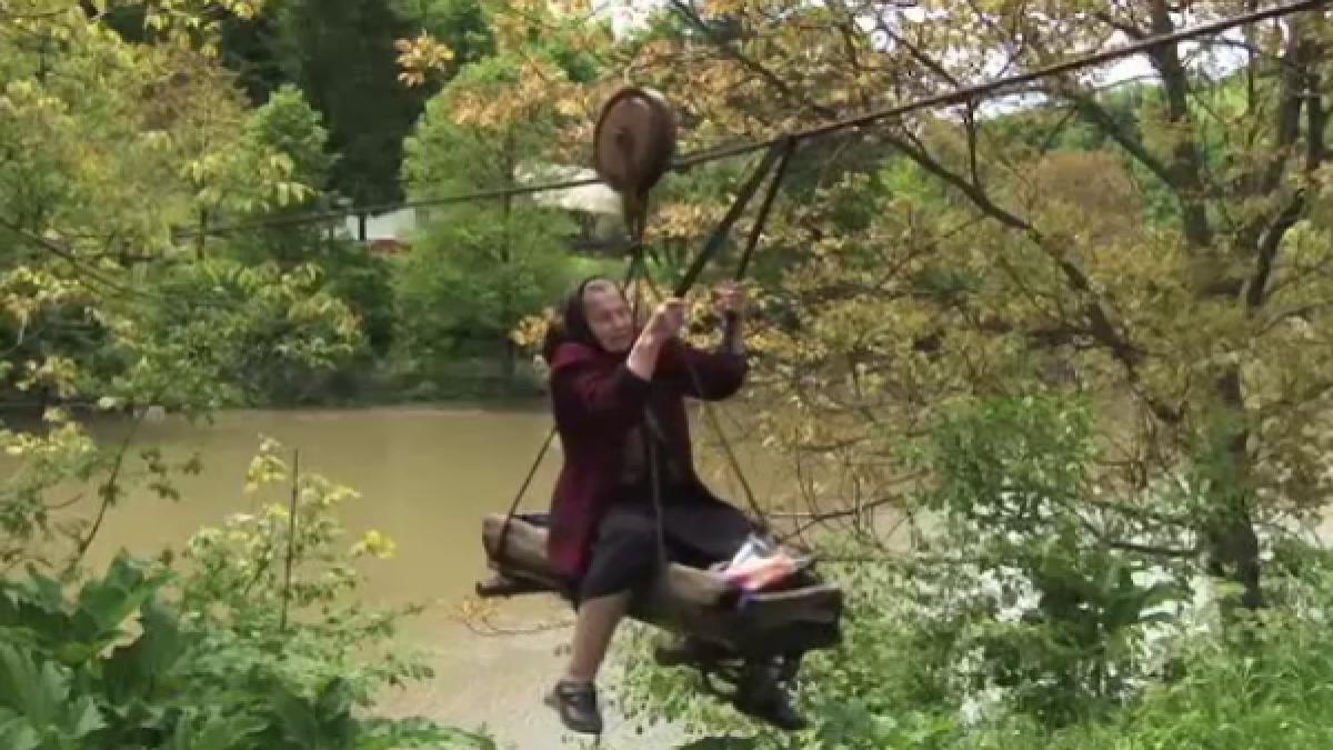 o batrana este nevoita sa traverseze zilnic un rau cu tiroliana pentru cumparaturi video