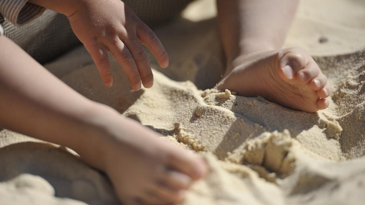 un copil s a impiedicat de ceva pe o plaja si a cazut curios a inceput sa sape in nisip e