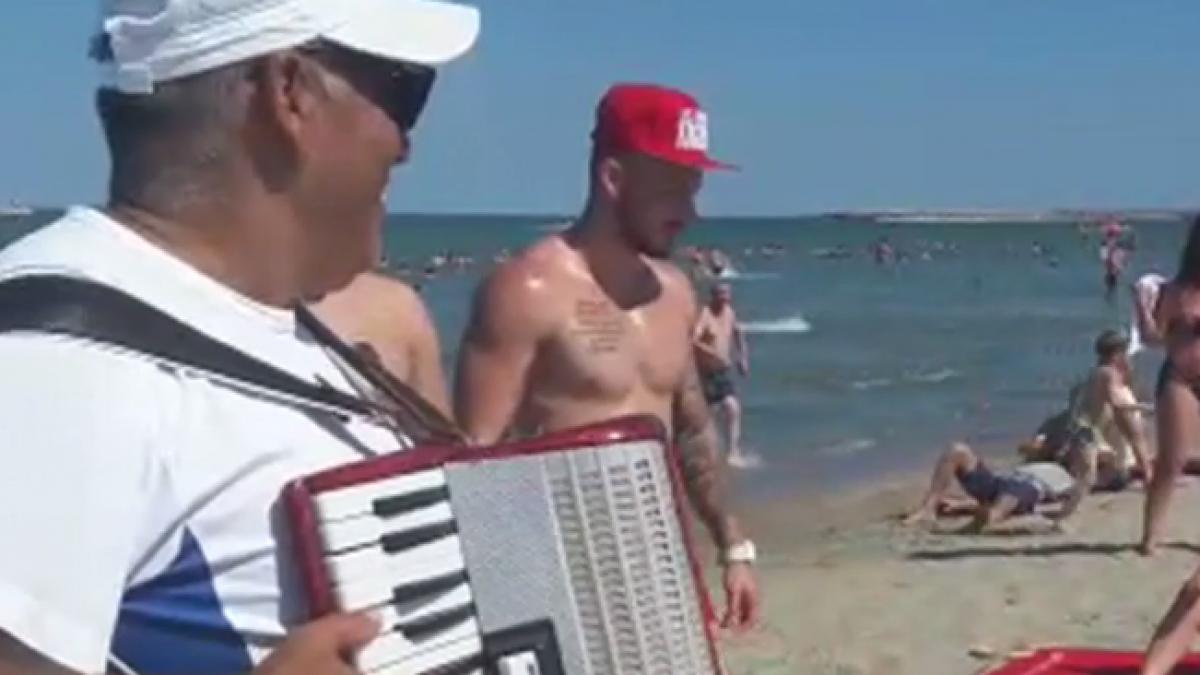 turistii se relaxeaza pe litoral lautarii canta la prosopul clientului