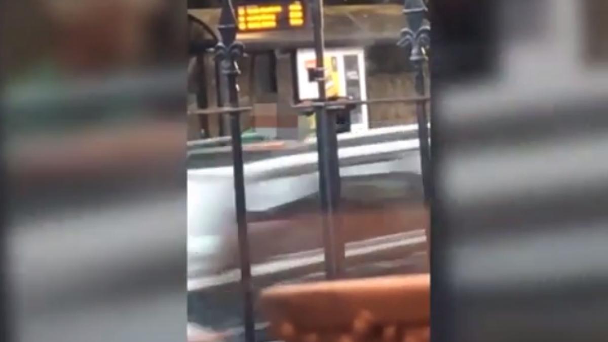 se uita pe geamul casei acolo unde se afla o statie de autobuz acolo unde doi indragostiti se