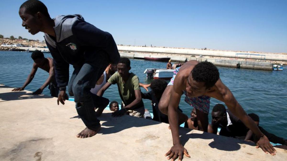 momentul in care o barca cu imigranti ajunge pe o plaja plina de turisti in spania