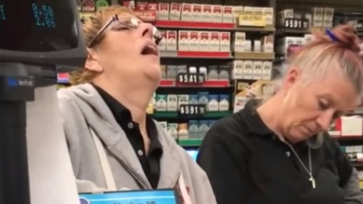 mai multi oameni asteptau la coada intr un magazin pentru a le fi scanate produsele ce faceau