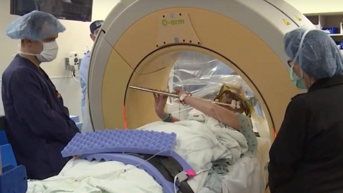 o femeie canta la flaut in timp ce este operata pe creier video