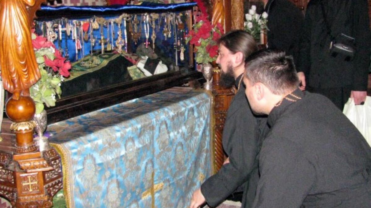 un sfant loveste geamul raclei in care se afla moastele sale