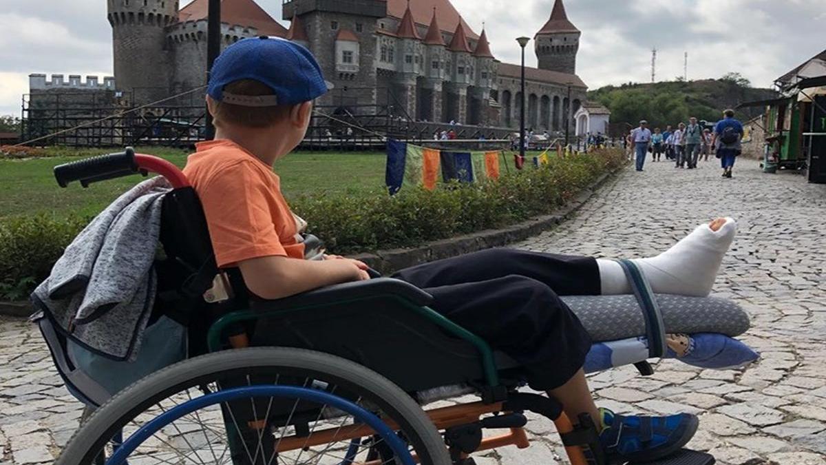 copil imobilizat temporar in scaunul cu rotile umilit in timpul unei vizite la castelul corvinilor