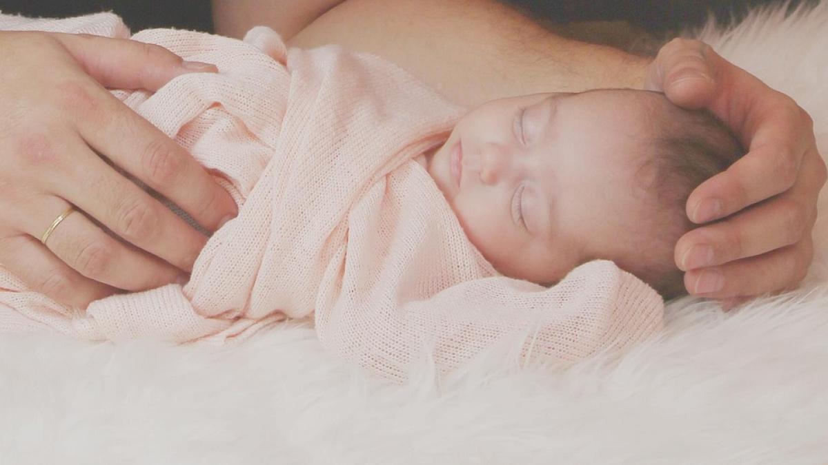 un bebelus adoarme linistit in bratele mamei sale fotografia ascunde insa un secret infiorator
