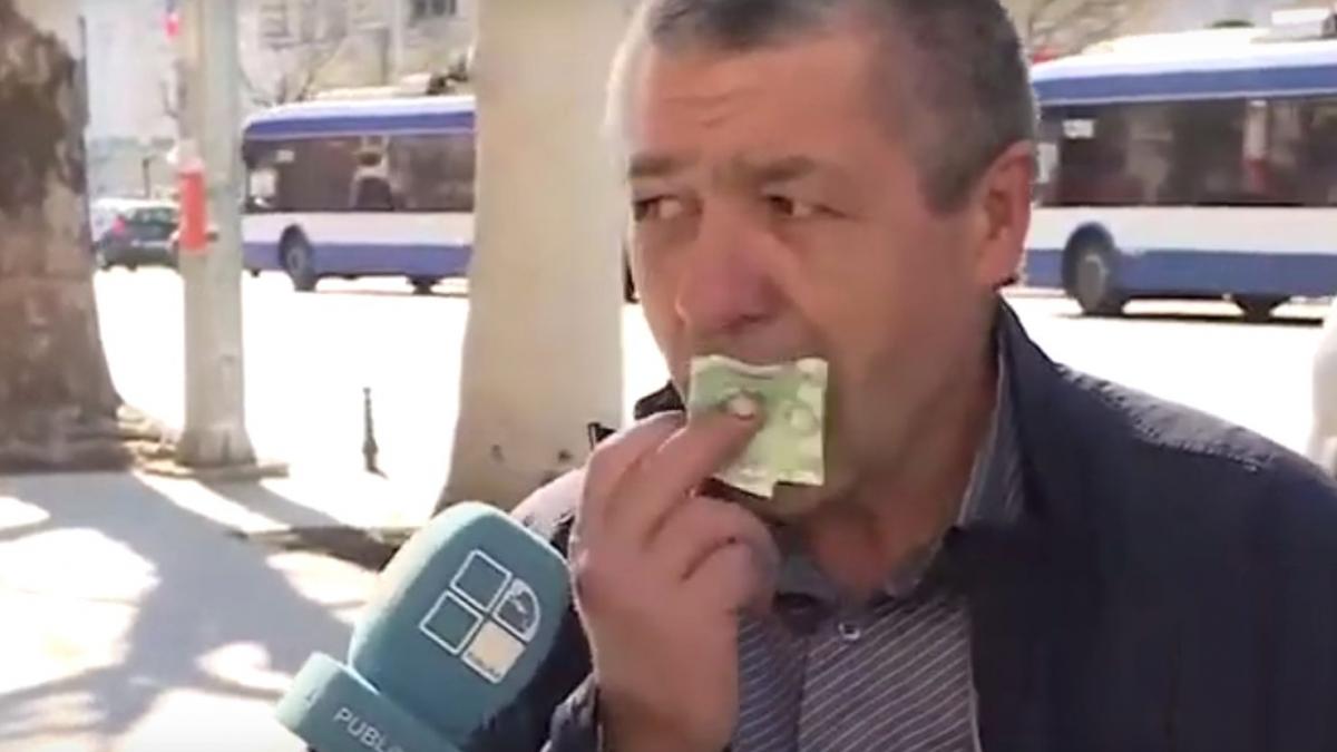 un barbat baga in gura o bancnota ca sa demonstreze ca pe bani nu s bacterii
