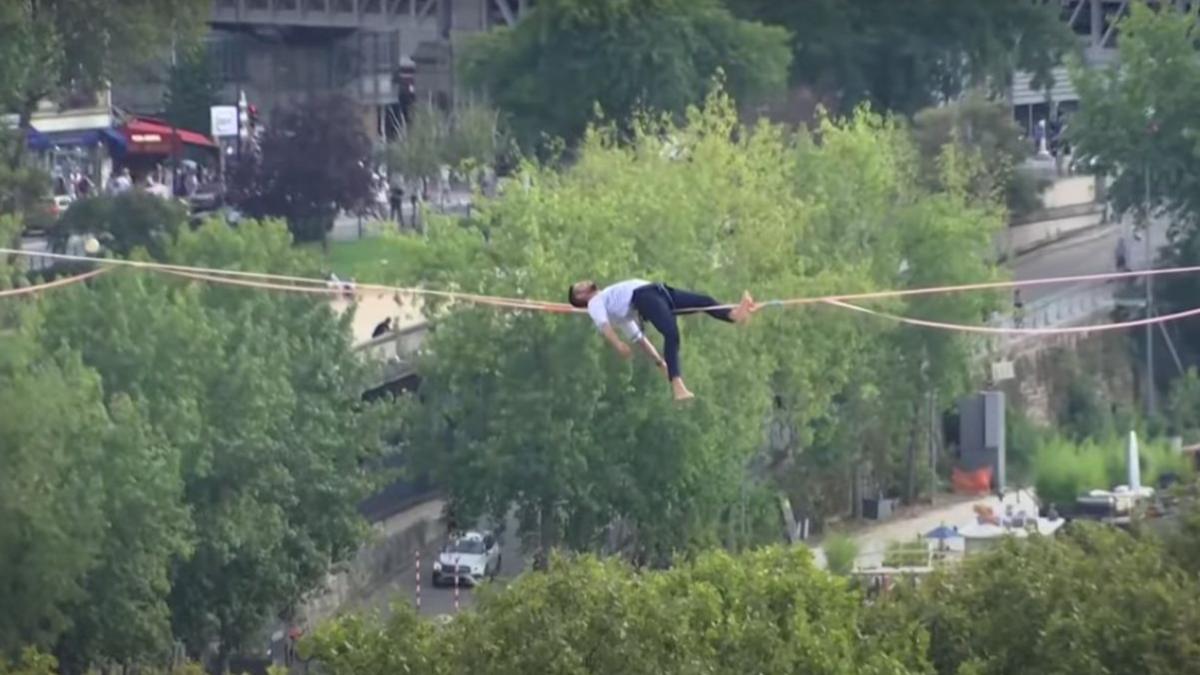 Acrobație la nivel înalt. Francezul Nathan Paulin s-a culcat pe coarda întinsă la 70 de metri înălțime, între Turnul Eiffel și Piața Trocadero