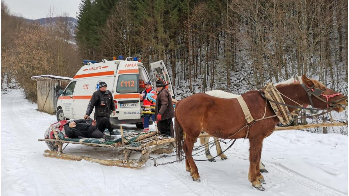 o batrana cu piciorul rupt dusa cu sania trasa de cai la ambulanta care nu putea urca de zapada
