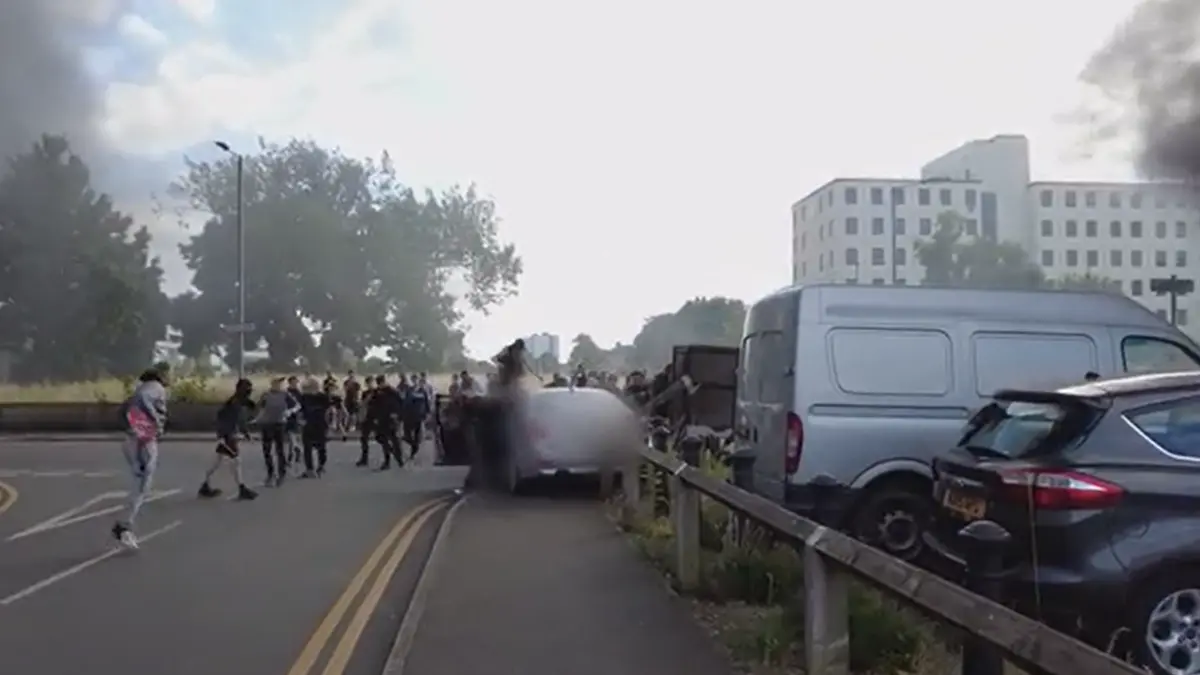imagini socante de la violentele din marea britanie un bmw cu est europeni este atacat de barbati albi care fac salutul nazist