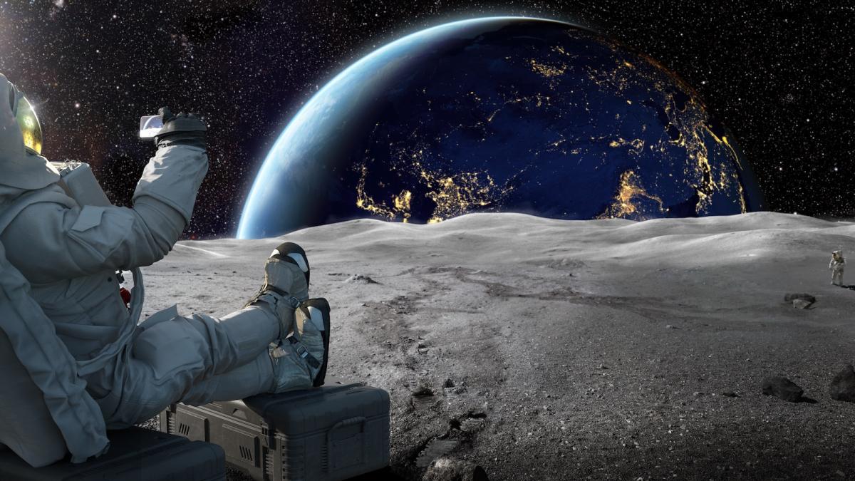 astronaut care filmeaza rasaritul cu telefonul in mana