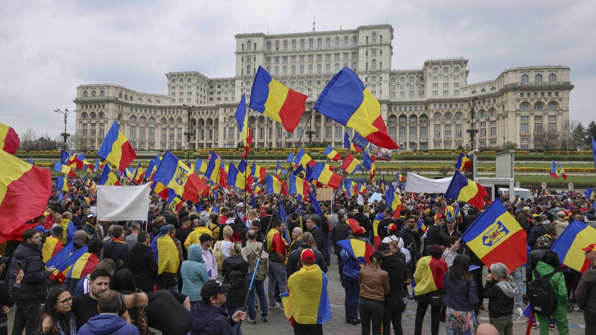 incidente la mitingul de ziua lui georgescu jandarmii scot din multime un legionar si o persoana care a fost violenta la alte proteste