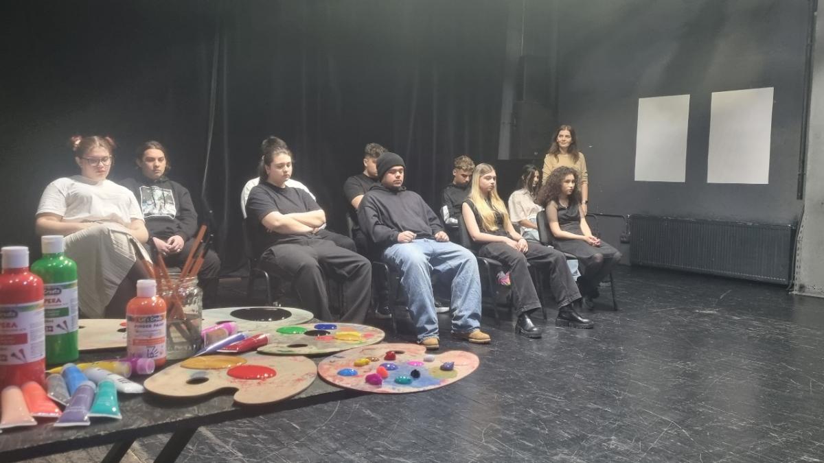 Adolescenti care joaca o piesa pe scena