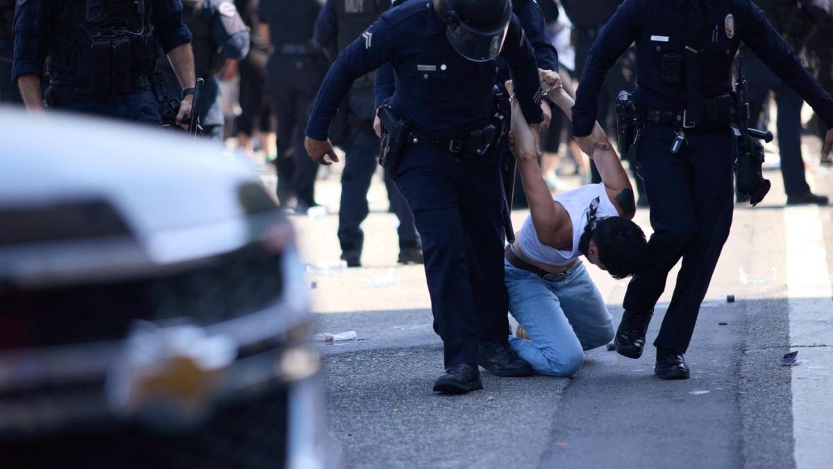 momentul in care un protestatar pe motocicleta se izbeste violent de o multime de politisti la protestele din los angeles