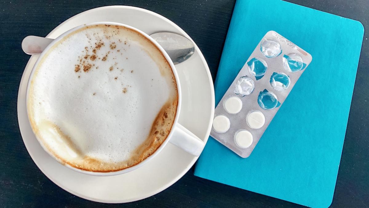 cafea cu lapte si medicamente langa ea