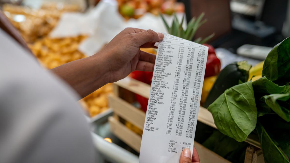 o femeie verifica bonul de cumparaturi