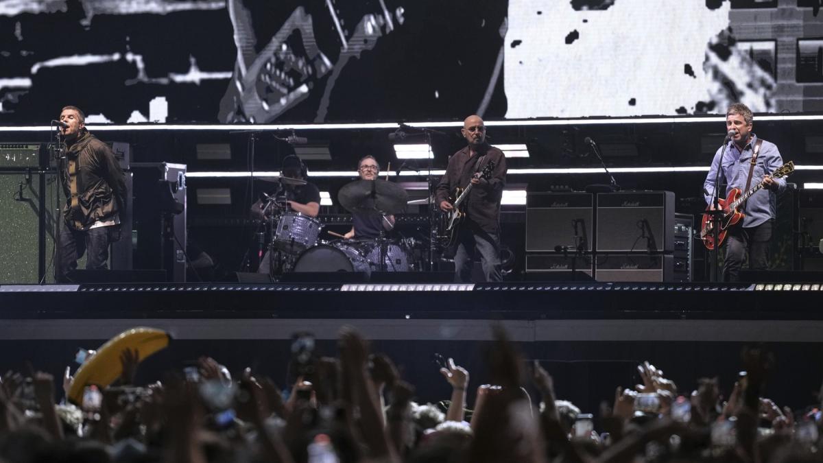 trupa oasis s a reunit dupa 16 ani fanii au umplut strazile din cardiff iar pretul biletelor a explodat