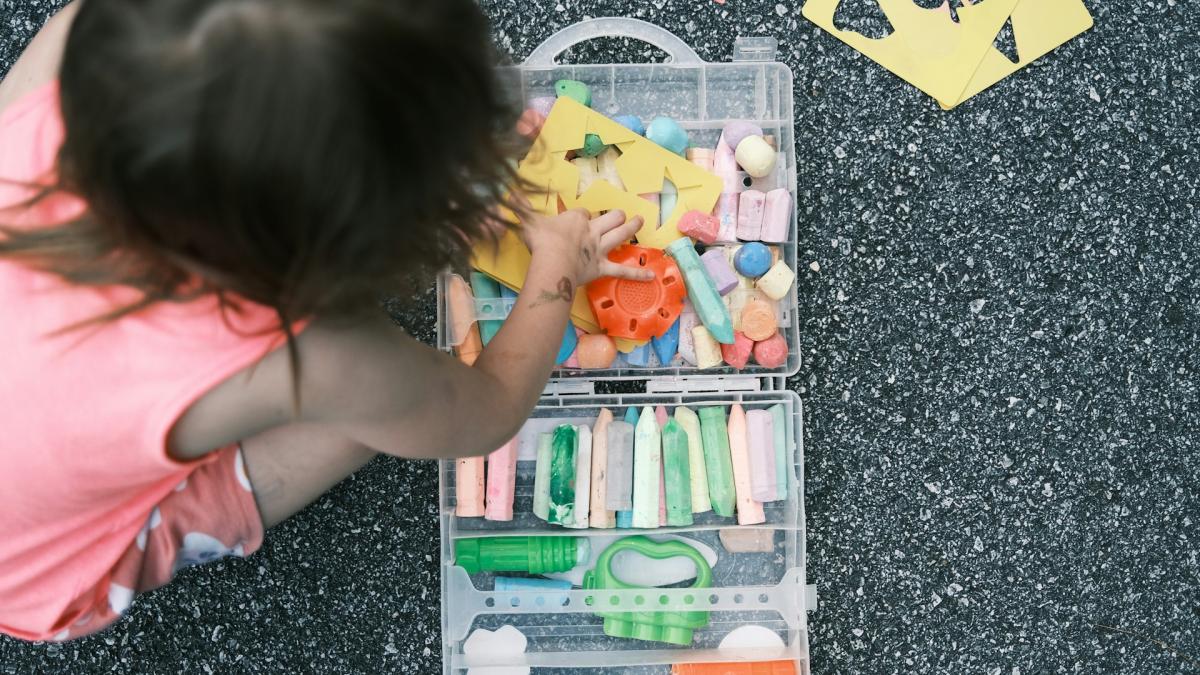 fetita care se joaca cu creta