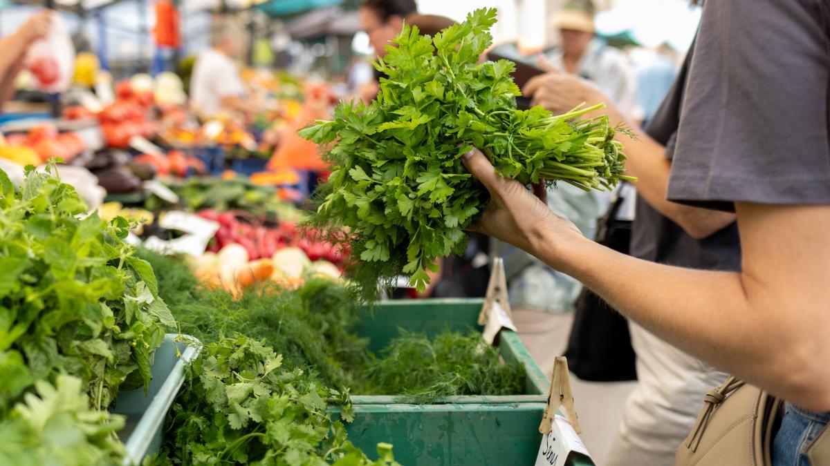 femeie care vinde patrunjel la piata