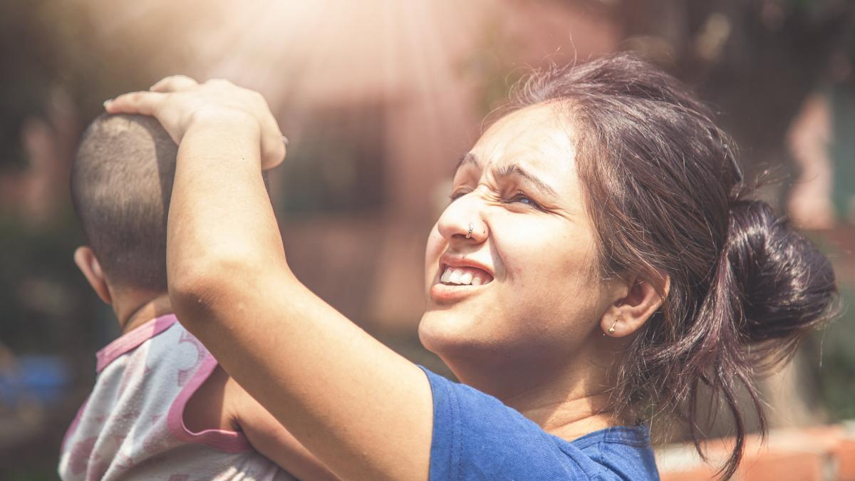 femeie tine mana pe capul unui copil 