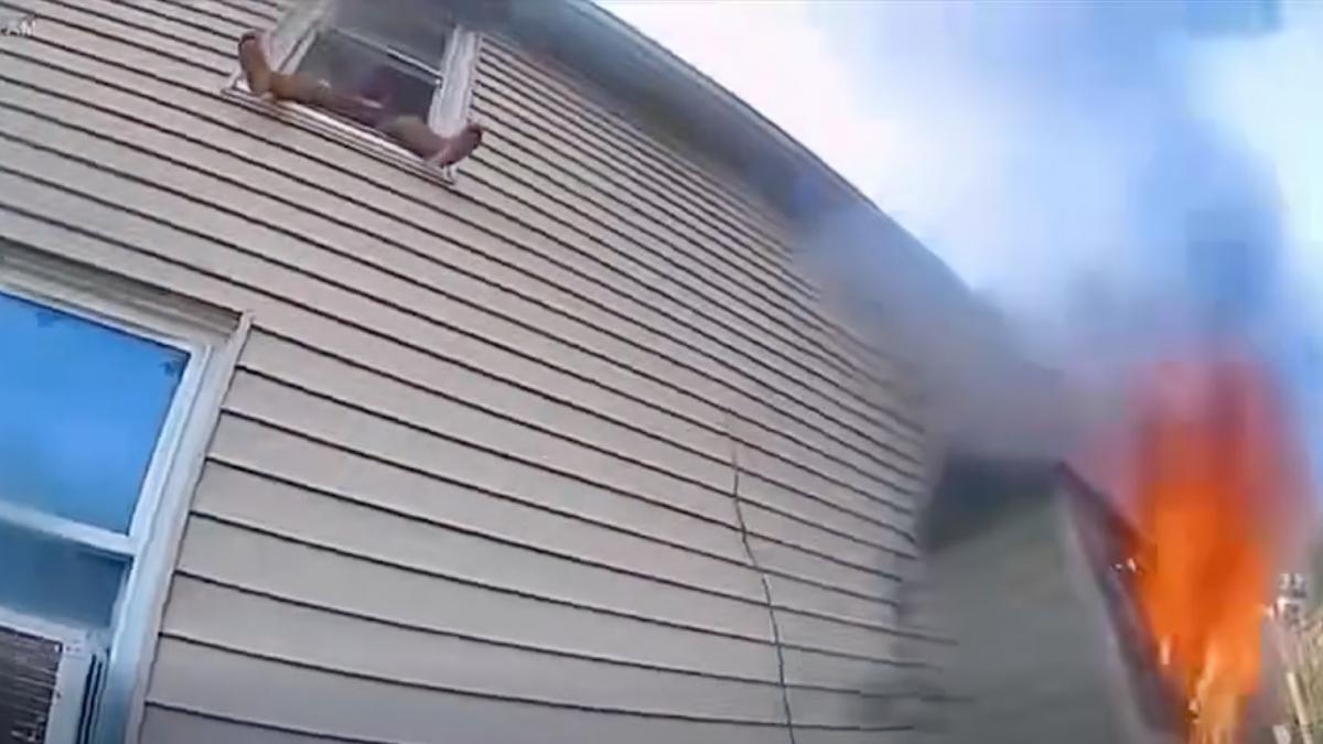 momentul in care un copil sare de la etaj in bratele politistilor din casa cuprinsa de flacari