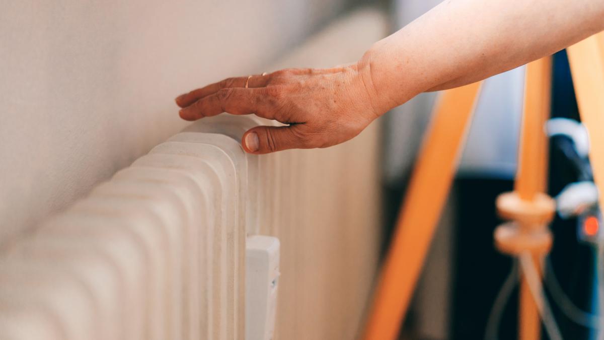 femeie verifica temperatura la calorifer