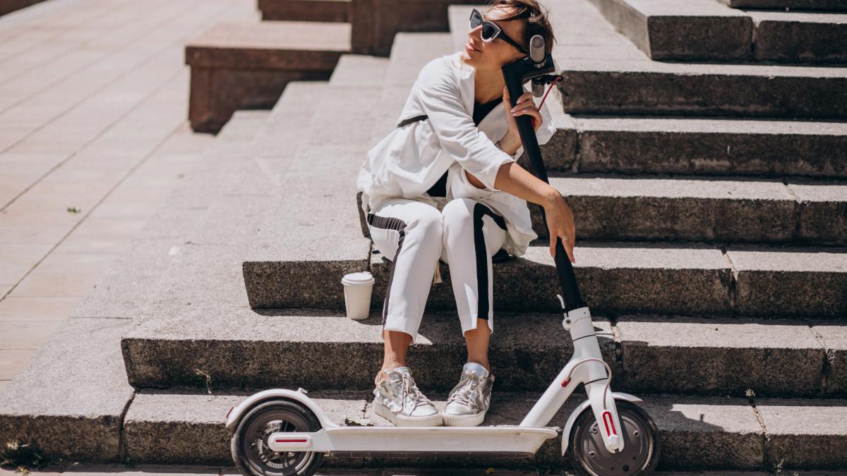 femeie care se sprijina de trotineta