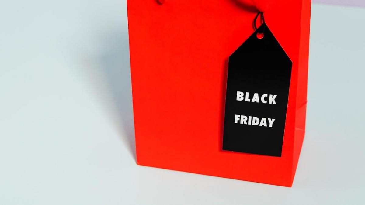 Etichetă neagră Black Friday legată de o pungă roşie.