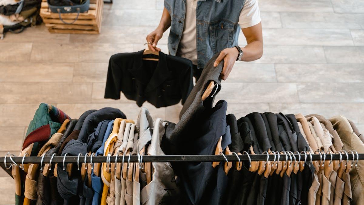 barbat aranjeaza haine suport umerase